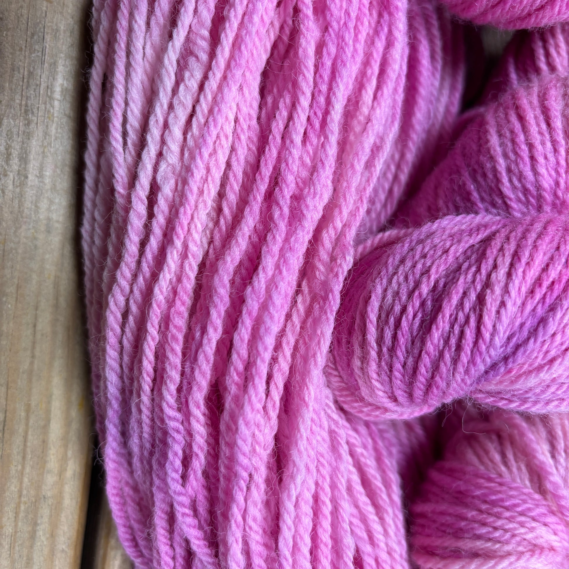 Close-up of pink yarn on a wooden surface